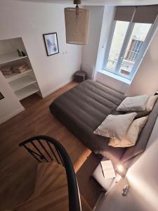 een groot bed in een kleine kamer met een stoel bij Charmant Duplex in Issoire