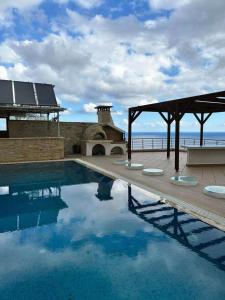 a swimming pool with a pavilion next to the ocean at Theseus beach with sea and sunrise view in Heraklio Town