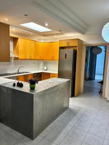 a kitchen with a counter and a stainless steel refrigerator at Theseus beach with sea and sunrise view in Heraklio Town
