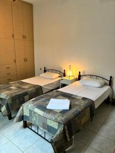 two beds sitting next to each other in a room at Theseus beach with sea and sunrise view in Heraklio Town