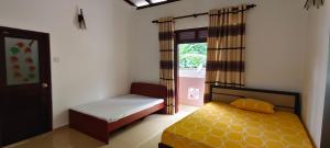 a small bedroom with a bed and a window at Roamers Ark Galle in Galle