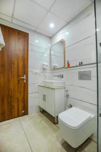 Un baño con inodoro, lavabo y espejo. en Hotel Hiltane Opposite VR Punjab Mall Airport Road Mohali Chandigarh, en Kharar