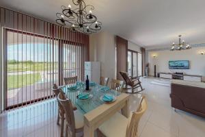 Un comedor y una sala de estar con mesa y sillas. en Villa Parnas at Lighthouse Golf by Parnas Estate, en Balchik