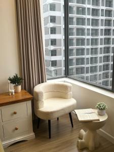 a chair in a room with a large window at Nghỉ dưỡng MT Eastmark in Xóm Ðội Bảy Ti