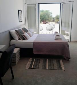 Un dormitorio con una cama grande y una ventana grande en Sunsets and Olive Trees, en Messini