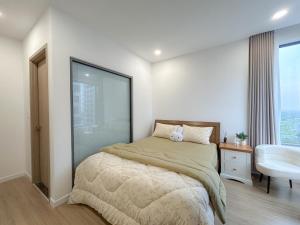 a bedroom with a bed and a chair and a window at Nghỉ dưỡng MT Eastmark in Xóm Ðội Bảy Ti