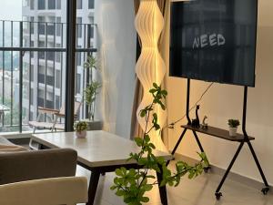 a living room with a table and a tv at Nghỉ dưỡng MT Eastmark in Xóm Ðội Bảy Ti