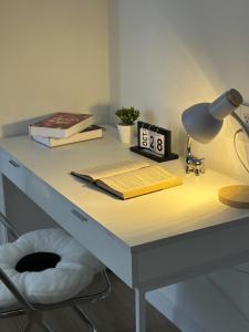 a desk with a lamp a alarm clock and books at Nghỉ dưỡng MT Eastmark in Xóm Ðội Bảy Ti