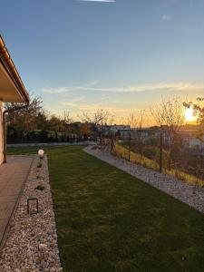 une cour herbeuse avec un chemin de pierres sur lequel se trouve un ballon dans l'établissement DoMi panorama&wellness, à Dudince