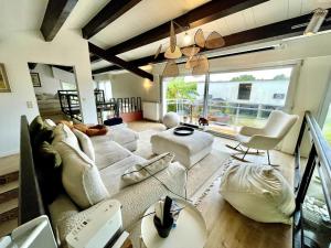 ein Wohnzimmer mit weißen Möbeln und einem großen Fenster in der Unterkunft La Villa au Bosquet in Belleville-sur-Vie