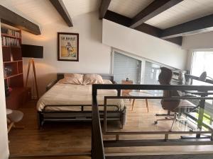 ein Schlafzimmer mit einem Bett und einem Schreibtisch in einem Zimmer in der Unterkunft La Villa au Bosquet in Belleville-sur-Vie