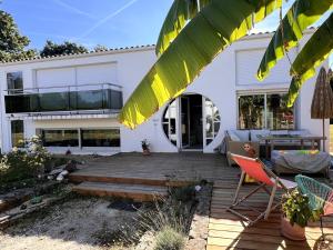 ein Haus mit Holzterrasse und Patio in der Unterkunft La Villa au Bosquet in Belleville-sur-Vie
