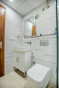 Un baño blanco con inodoro y espejo. en Hotel Hiltane Opposite VR Punjab Mall Airport Road Mohali Chandigarh, en Kharar 55 fotos más