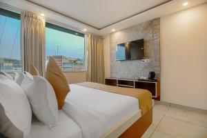 una habitación de hotel con una cama y un televisor en Hotel Hiltane Opposite VR Punjab Mall Airport Road Mohali Chandigarh, en Kharar