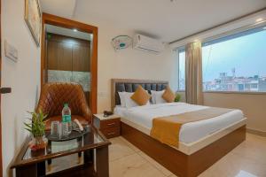 Un dormitorio con una cama y una mesa y una ventana. en Hotel Hiltane Opposite VR Punjab Mall Airport Road Mohali Chandigarh, en Kharar