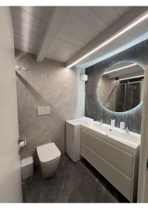 a bathroom with a sink and a toilet and a mirror at Dinastia Case Snow Apartment in Passo del Tonale +44 photos
