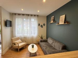 a living room with a couch and a table at Maison Entre Verre et Mer in Eu