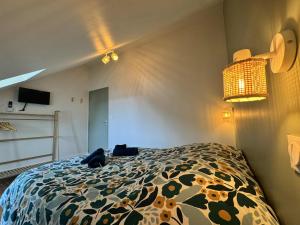 a bedroom with a bed with a flowered comforter at Maison Entre Verre et Mer in Eu +8 photos