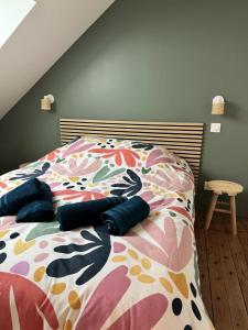 a bedroom with a bed with a floral bedspread at Maison Entre Verre et Mer in Eu