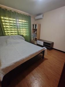 a bedroom with a bed and a window with a fan at David home in Manila