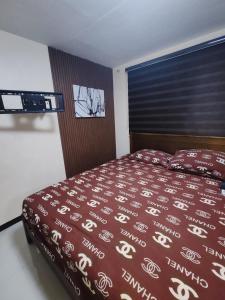 a bedroom with a bed with a red comforter at David home in Manila