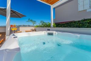 a hot tub in the backyard of a house at Family friendly seaside apartments Iz, Iz - 22025 in Veli Iž