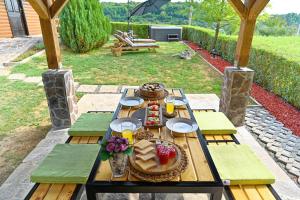 ドゥガ・レサにあるFamily friendly house with a parking space Mihalic Selo, Karlovac - 22351の木製テーブル(食べ物付)が備わるパティオ