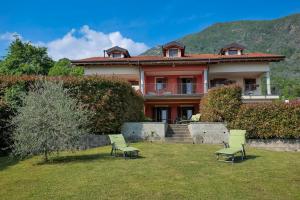 a house with two chairs in the yard at Villetta dei Pascoli in Baveno