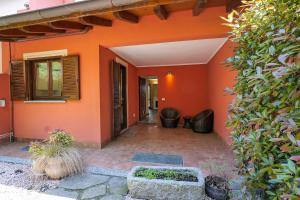 an orange house with a patio and a courtyard at Villetta dei Pascoli in Baveno