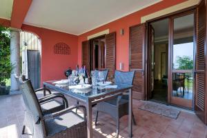 a dining room with a table and chairs on a patio at Villetta dei Pascoli in Baveno
