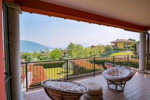 a balcony with two chairs and a view at Villetta dei Pascoli in Baveno