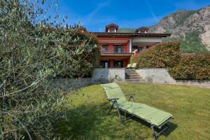 a chair sitting in the grass in front of a house at Villetta dei Pascoli in Baveno