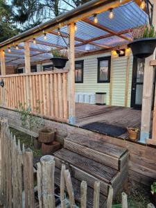 een houten terras met een pergola met potplanten erop bij Lodge Priscilla in Eext