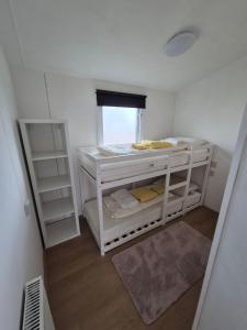 een kleine kamer met witte stapelbedden en een raam bij Lodge Priscilla in Eext +17 foto's