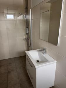 a white bathroom with a sink and a mirror at Stadtquartier Völkermarkt in Völkermarkt