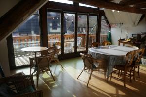 a dining room with a table and chairs and windows at Plein Sud vue sur les Vosges et le vignoble in Ammerschwihr