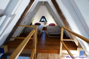 a attic room with two beds and a ladder at Plein Sud vue sur les Vosges et le vignoble in Ammerschwihr