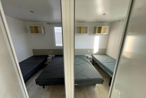 En eller flere senge i et værelse på Mobil home G107 Camping les VIGNES Lit-et-Mixe + 12 billeder