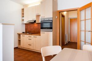 una cucina con mobili bianchi e un tavolo con sedie di Apartmán IRIS Poděbrady 3 a Poděbrady Altre 6 foto