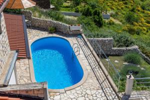 an overhead view of a swimming pool in a yard at Family friendly house with a swimming pool Lokva Rogoznica, Omis - 4328 in Lokva Rogoznica