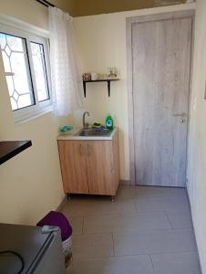 a small kitchen with a sink and a door at Stefanos Garden3 in Arménoi