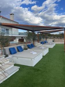 eine Terrasse mit weißen Kissen und blauen Zierkissen in der Unterkunft Family friendly house with a swimming pool Maslenica, Novigrad - 20492 in Maslenica