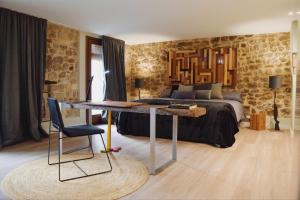 a bedroom with a bed and a desk in front of it at Kel Domènech Luxury Apartment in Besalú