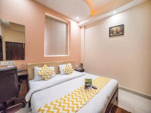 a bedroom with two beds and a desk and a television at Hotel Atithi Inn in Gwalior