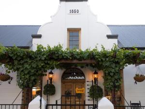 a white building with a bunch of ivy on it at Adderley House Guest Accommodation in Robertson