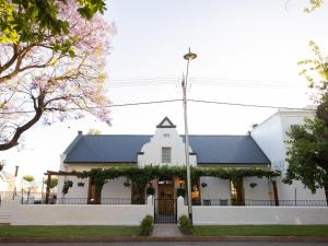 a white church with a black roof at Adderley House Guest Accommodation in Robertson