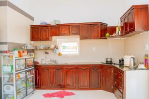 a kitchen with wooden cabinets and a refrigerator at Tan Duy Hotel in Xuyên Mộc