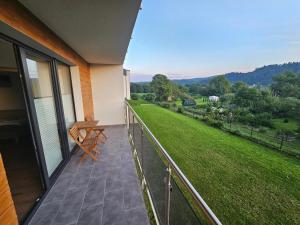 einen Balkon eines Hauses mit Blick auf einen Hof in der Unterkunft Komfortowy, klimatyzowany apartament Góry Marzeń - Lesko in Lesko + 5 Fotos