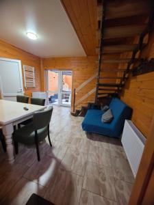 uma sala de estar com uma mesa e um sofá azul em Carpe Diem em Chistilov