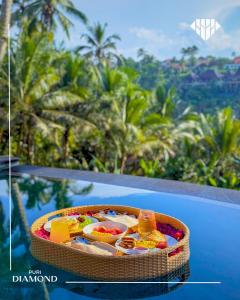 a basket of food sitting on a ledge with palm trees at Puri Diamond Villas in Tampaksiring +48 photos